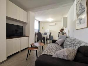 a living room with a couch and a table at Élégant duplex proche du centre-ville in Miramas