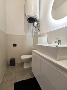 a white bathroom with a sink and a toilet at Élégant duplex proche du centre-ville in Miramas