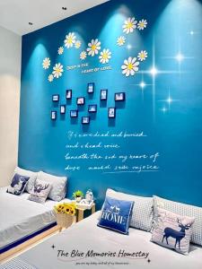 a bedroom with a blue wall with flowers and a bed at The Blue Memories Homestay (Mediterranean Style) in Sungai Pelik