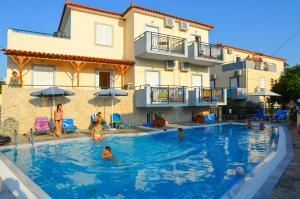 a group of people in a swimming pool in front of a building at VIRGINIA STUDIOS in Anaxos