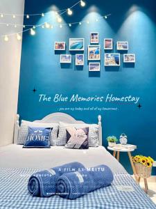 a bedroom with a blue wall with pictures on it at The Blue Memories Homestay (Mediterranean Style) in Sungai Pelik