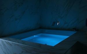una vasca blu in una stanza con pareti in marmo di The Saint stays a Bari