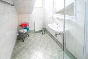 Baño blanco con lavabo y espejo en Ferienhaus Ennsling, en Haus im Ennstal