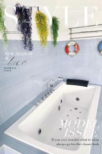 a white bath tub in a bathroom with blue tiles at The Blue Memories Homestay (Mediterranean Style) in Sungai Pelik