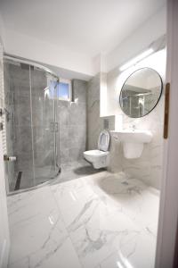uma casa de banho com um chuveiro, um lavatório e um WC. em Blue Tower Apartments em Suceava