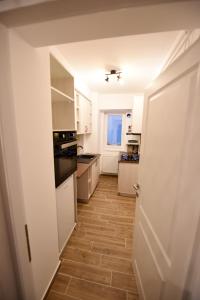 a kitchen with white cabinets and a wooden floor at Blue Tower Apartments in Suceava