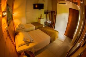 a hotel room with two beds and a television at Pousada Fortaleza in Fernando de Noronha