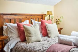 a bed with a bunch of pillows on it at The Dalesman Country Inn in Sedbergh