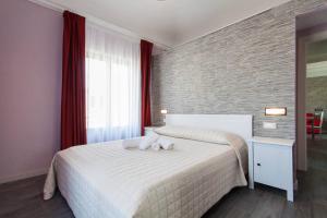 カステッランマーレ・デル・ゴルフォにあるEmporiumのベッドルーム(赤いカーテン付きの白い大型ベッド1台付)