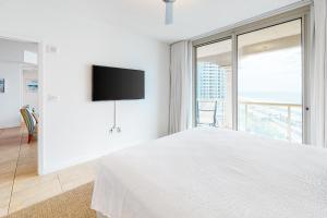 Dormitorio blanco con cama y ventana grande en Portofino Island Resort and Spa Tower One 1108, en Pensacola Beach