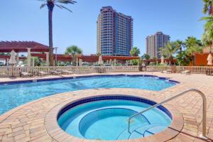 una piscina en un complejo con palmeras y edificios en Portofino Island Resort and Spa Tower One 1108, en Pensacola Beach