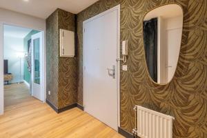 a hallway with a door and a mirror on a wall at Florentine Furnished flat in Annecy