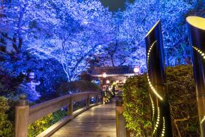 Grand Prince Hotel Shin Takanawa في طوكيو: ممشى في حديقة بها أضواء زرقاء