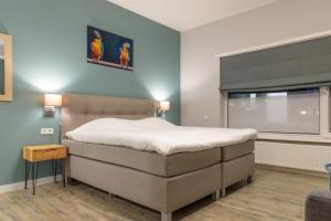 a bedroom with a bed and a window at Hotel 't Paviljoen in Rhenen