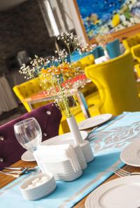una mesa con un paño de mesa azul y un jarrón con flores en Demosan City Hotel, en Konya