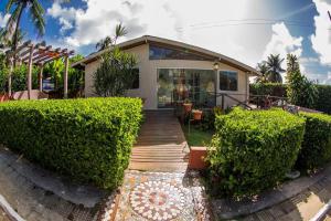 a house with a wooden walkway in front of it at Pousada Fortaleza in Fernando de Noronha