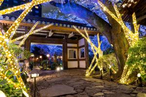 東京的住宿－高輪花香路旅館，一座花园,在一座建筑前有圣诞灯