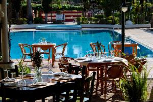 a table and chairs in front of a swimming pool at Bungalows Club Aire Libre in Tossa de Mar