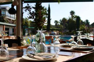 a table with glasses and plates on a table with a pool at Bungalows Club Aire Libre in Tossa de Mar