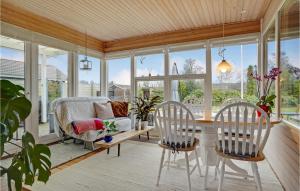 een afgeschermde veranda met een tafel en twee stoelen bij Beautiful Home In Middelfart With Kitchen in Middelfart