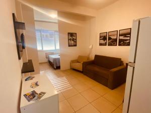 uma sala de estar com um sofá e uma cama em Studio completo ENTRADA pela PRAIA DE COPACABANA, com ar, wifi, netflix, até 4 pessoas, pauloangerami AA3806 em Copacabana