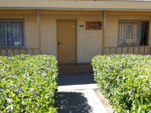 un edificio con arbustos delante de una puerta en Residencial Las Palmeras, en Iquique