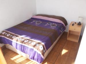 Cama pequeña en habitación con mesa en Residencial Las Palmeras, en Iquique