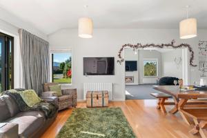 a living room with a couch and a table at Cedar Sanctuary - Albert Town Holiday Home in Wanaka