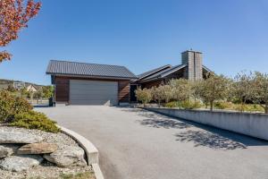 a driveway leading to a house with a garage at Cedar Sanctuary - Albert Town Holiday Home in Wanaka