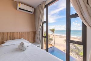 um quarto com uma cama e vista para a praia em Varandas do Mar Condomínio Moderno por Carpediem em Caucaia