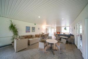 a living room with a couch and tables and chairs at Hössensportzentrum in Westerstede