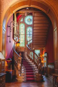 un escalier en colimaçon dans un bâtiment doté d'un vitrail dans l'établissement Château La Marquise, à Saumur