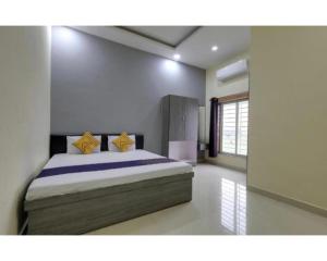 Un dormitorio con una cama con almohadas amarillas. en Siddhi Vinayak Hotel & Marriage Garden, Chandukhedi, en Ujjain