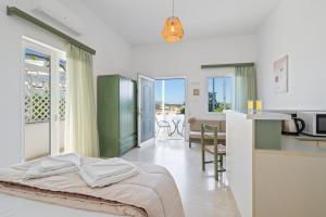 ein Schlafzimmer mit einem Bett und eine Küche mit einem Tisch in der Unterkunft Eolos Apartments in Chania