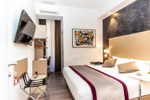 ローマにあるCalisto Luxury Trastevereのベッドとテレビ付きのホテルルーム