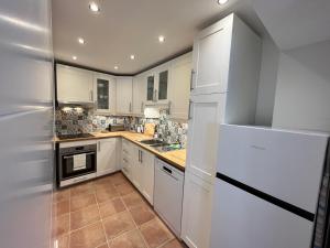 a kitchen with white cabinets and a white refrigerator at Calle Carabeo 57 in Nerja