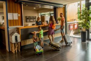 een groep mensen in een lobby met bagage bij Résidence Terschelling in Midsland