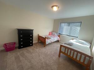 a bedroom with two beds and a dresser and a window at Spacious 2 bedroom in Chevy chase in Chevy Chase