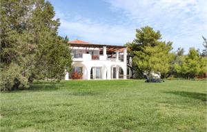 a large white house with a green yard at Soleiliosonne Haus Zeus in Ermioni