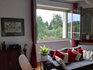 uma sala de estar com um sofá e uma grande janela em Soleil levant em Nieul