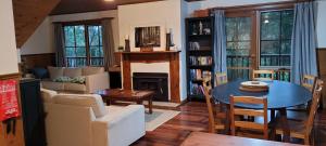 a living room with a table and a fireplace at Tall Trees Eco Retreat - Fern Cottage in Apollo Bay