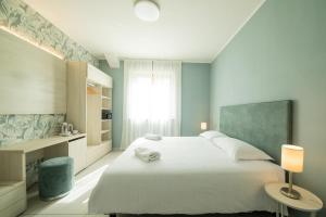 una camera da letto con un grande letto bianco e una finestra di Lei Rooms a Maranello