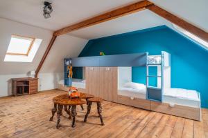 Cette chambre est dotée d'un mur bleu et de lits superposés. dans l'établissement Chez Marin - Idéal pour 12 voyageurs, à Plomodiern