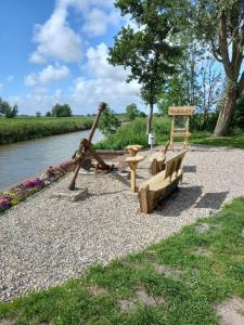 a playground with a swing and a bench next to a river at *Engels - Ferienwohnungen in Visquard