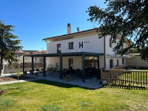 a large white building with a patio in a yard at Hotel Rural Covarrubias in Covarrubias