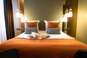 ein Bett mit einem Buch und einem Teller Essen drauf in der Unterkunft Hotel de la Poste in Corps