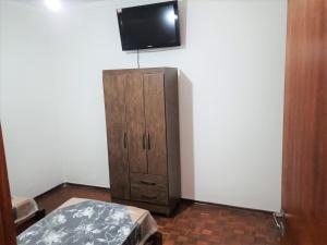 a room with a cabinet and a flat screen tv at MX RESIDENCIAL in Jaú