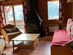 una sala de estar con estufa de leña en una cabaña en Chalet Pra-Loup, 4 pièces, 10 personnes - FR-1-165A-62 en Uvernet