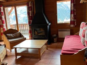 a living room with a wood stove in a cabin at Chalet familial, 3 chambres, 10 pers, Pralou 1500 - FR-1-165A-62 in Uvernet-Fours