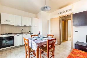 a kitchen with a table and chairs in a kitchen at DORMIGLIONE APARTMENT in Torre Lapillo